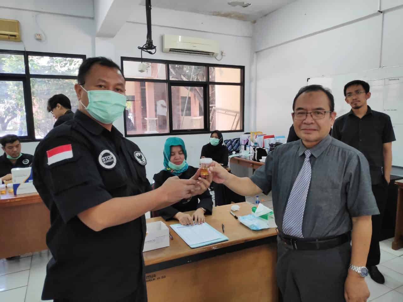 Rektor Unisma Bekasi, Dr. Nandang Najmulmunir, Ir., M.S, menyerahkan urine kepada petugas